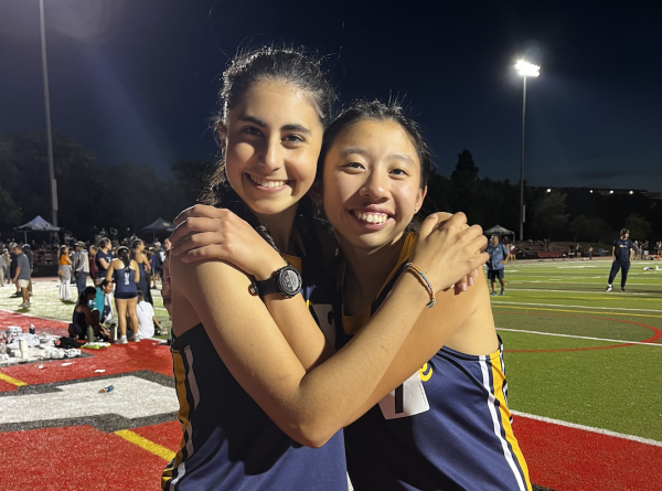 Senior track athletes Lily Henry and Andie Wong pose during their last meet. 